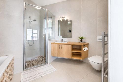 a bathroom with a shower and a toilet and a sink at Jetty Seaview Apartment in Swakopmund