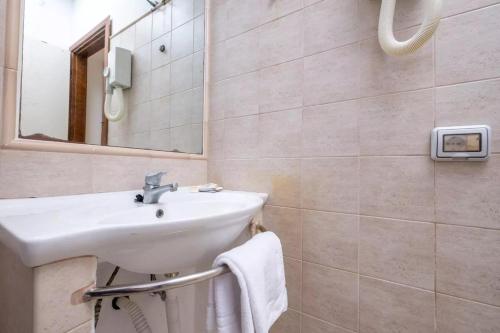 a bathroom with a sink and a mirror at JERA Holiday Collection VULCANO UNO - Garden View in Vulcano