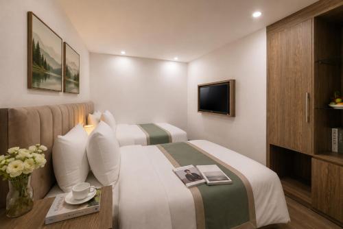 a hotel room with two beds and a tv at Emissary Corner Hanoi Hotel & Spa in Hanoi