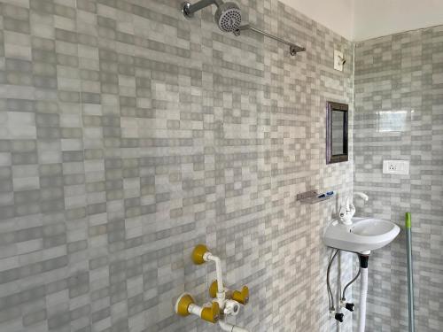 a bathroom with a sink and a shower at Senamura Yoga Ashram Guesthouse in Bodh Gaya