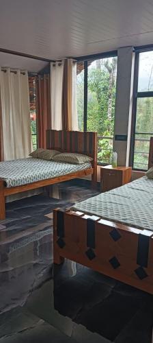 two beds sitting in a room with windows at Mount Star Home Stay in Kakkabe