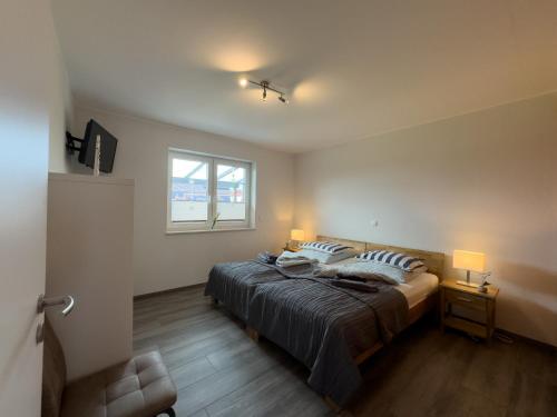 a bedroom with a bed with two pillows and a window at Friese24 in Wangerland