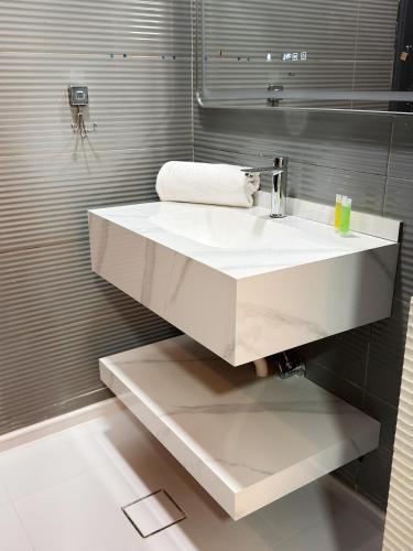 a bathroom with a white sink and a mirror at Natalie Aqua villa heated pool 3BD DeadSea in Al Kafrayn