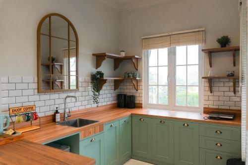 a kitchen with blue cabinets and a sink and a window at Suka Village 