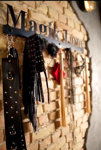 a wall with umbrellas hanging from a brick wall at Magik Love Apartament in Piła
