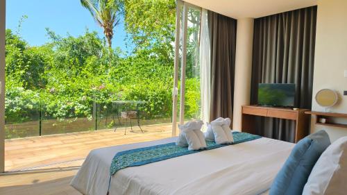 a bedroom with a bed and a large window at Villa Monsoon in Nathon Bay
