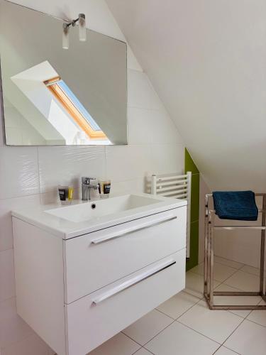 a white bathroom with a sink and a mirror at Villa Métisse Ile et Villas Groix in Groix