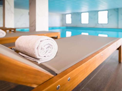 a towel is sitting on top of a bed at Mercure Hotel & Spa Bastia Biguglia in Biguglia