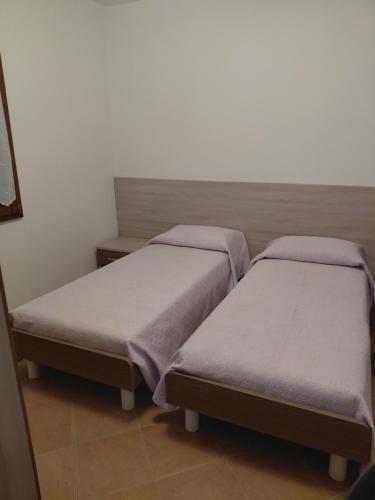 two twin beds in a room withermottermottermottermott at Dolce casa in Saone