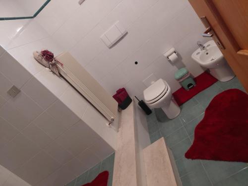 a white bathroom with a toilet and a sink at Dolce casa in Saone