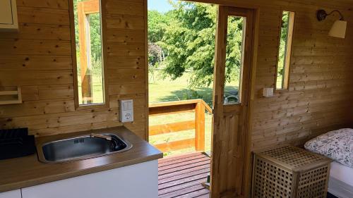 a kitchen with a sink in a wooden cabin at Sonnenhof Uckermark in Lübbenow