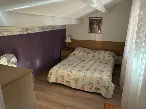 a bedroom with a bed with a bedspread on it at Résidence Sofia Lynda in Le Plan-de-la-Tour