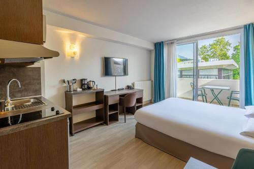 a hotel room with a bed and a kitchen at Les Loges du Park - Résidence hôtelière in Aix-les-Bains