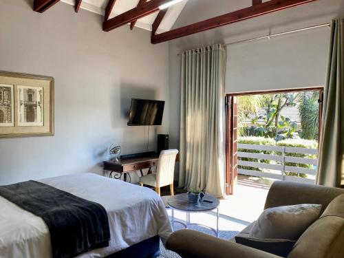 a bedroom with a bed and a desk and a window at CView Suites & Apartments in Pretoria