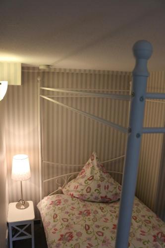 a bedroom with a bed with a blue bed frame and a lamp at Derhof in Eldagsen