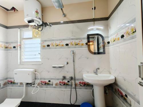 a bathroom with a shower and a toilet and a sink at Lokenath Resort in Tarapith