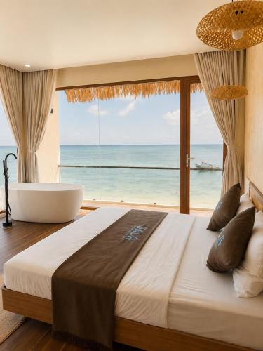 a bedroom with a large bed with a view of the ocean at Sala Beach Villa Phú Quý in Cù Lao Thu