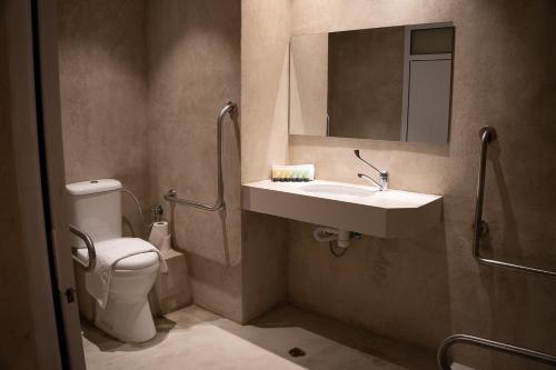 a bathroom with a toilet and a sink and a mirror at Lumi Hotel Eilat - מלון בוטיק באילת in Eilat