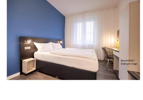 a hotel room with a bed and a desk at Hostel Art & Style in Singen