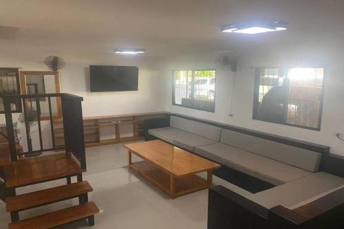 a living room with a couch and a tv at Angelito's Beach House Siargao near Beach in General Luna