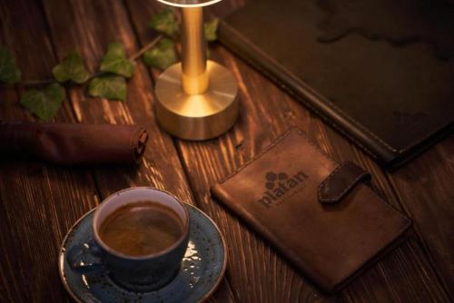 a cup of coffee on a table next to a wallet at Platan in Samarkand