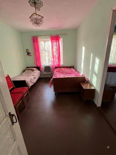 a room with two beds and a chair in it at Antarut Garden House in Antarut