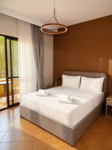 a bedroom with a large bed with white sheets at Azel Boutique Hotel in Draç