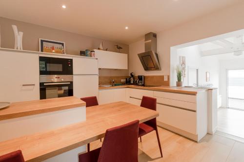 a kitchen with a wooden table and a dining room at Libellule - Proche plage - Terrasse in Pornichet