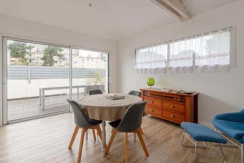a dining room with a table and chairs and a window at Libellule - Proche plage - Terrasse in Pornichet