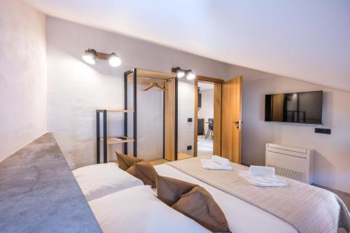 two beds in a room with a tv on the wall at Lasa Pur Dir in Piran