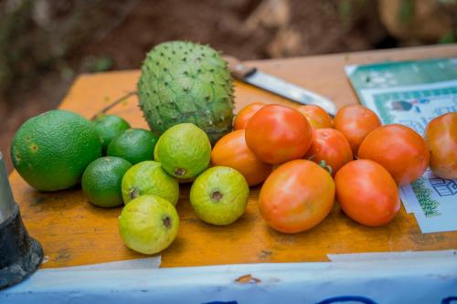 a bunch of fruit sitting on a wooden table at Gejja Cottage in Lwanga