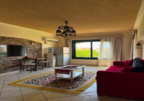 a living room with a red couch and a table at Luxury Chalet - La Hacienda in Ras Sedr