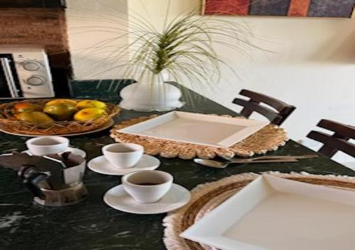 a table with a bowl of fruit and cups of coffee at Luxury Chalet - La Hacienda in Ras Sedr