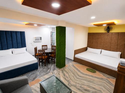 a hotel room with two beds and a table at Hotel Parinay Vatika in Deoghar