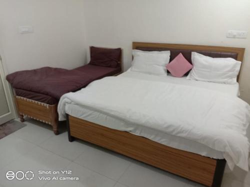 two twin beds in a room with aermott at Hotel Kalaptaru in Nainital