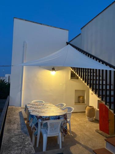 a table and chairs on a patio with a white tent at tata Uccio in Matino