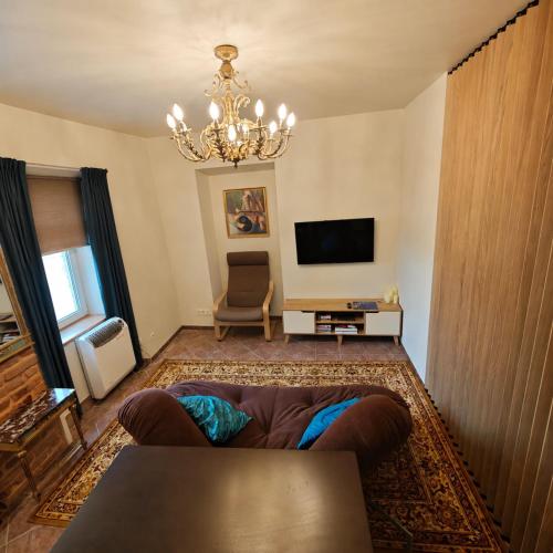 a living room with a couch and a television at Old town boutique apartaments in Ukmergė