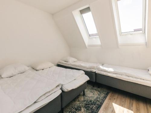 two beds in a room with two windows at Møn - Klintholm Harbour in Borre