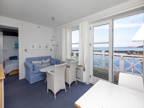 a living room with a blue couch and a balcony at Møn - Klintholm Harbour in Borre