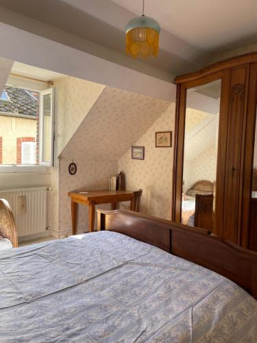 a bedroom with a large bed and a window at Chez Merlin le brocanteur in Charny