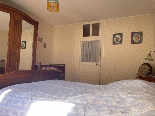 a bedroom with a bed and a white door at Chez Merlin le brocanteur in Charny