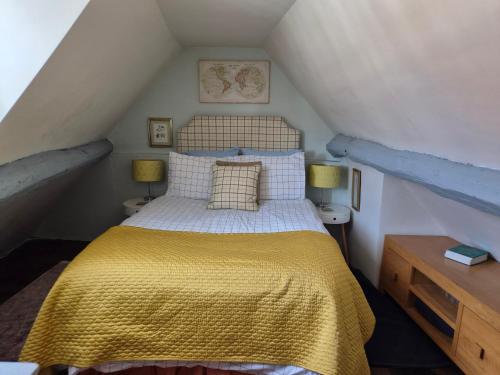 a bedroom with a bed with a yellow blanket at The Poop Deck in Upton upon Severn