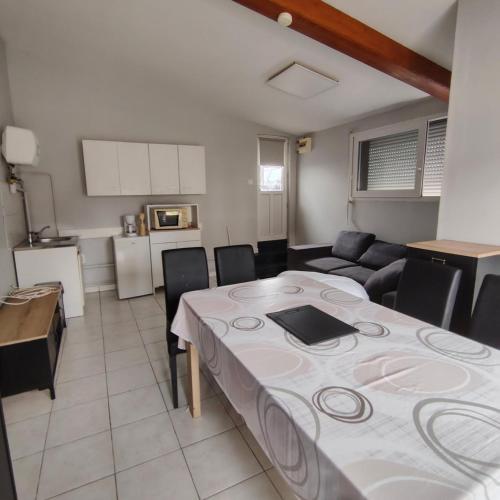 a kitchen and living room with a table with a laptop on it at L’Adresse 262 