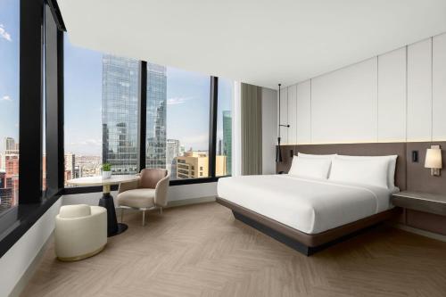 a hotel room with a bed and a desk and windows at AC Hotel by Marriott Manila in Manila