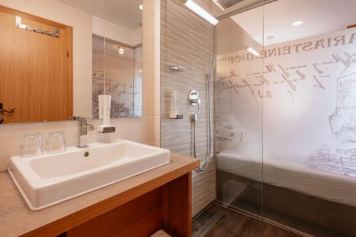 a bathroom with a sink and a shower at Hotel Mariasteinerhof in Mariastein