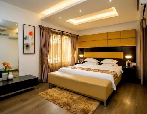 a bedroom with a large bed and a large window at D'more Dhaka Hotel & Resort in Dhaka