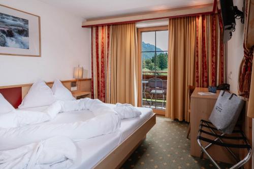a hotel room with a bed and a window at Hotel Mariasteinerhof in Mariastein