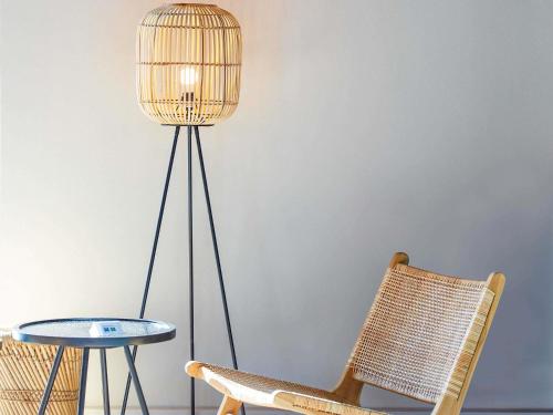a floor lamp next to a table and a chair at ibis Styles Bayreuth in Bayreuth