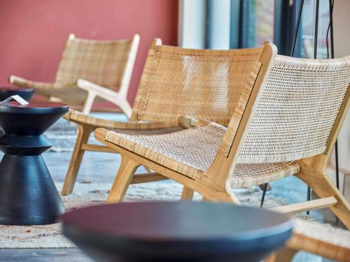 two wicker chairs sitting in a room with a table at ibis Styles Bayreuth in Bayreuth