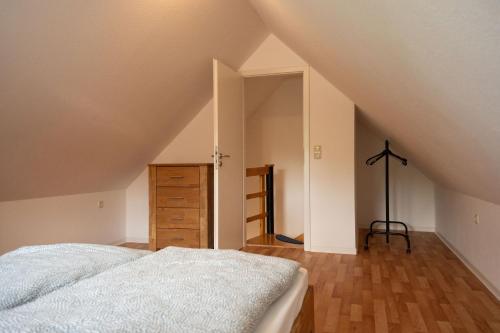 a bedroom with a bed and a dresser in a attic at Haus Figaro mit Hund in Wangerland